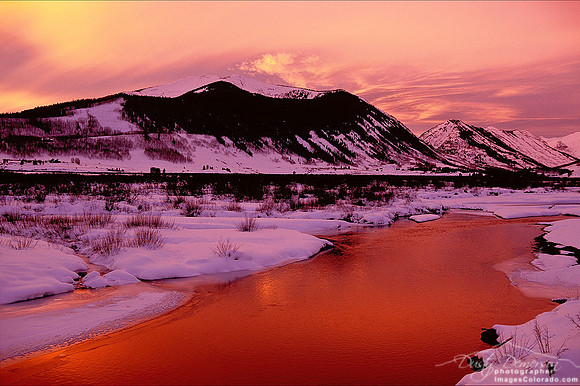 A deep red sunset fills the sky around Mount Emmons also known as The Red Lady